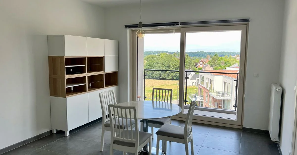 Une salle à manger contemporaine avec des meubles modernes et une vue pittoresque à travers une grande fenêtre.