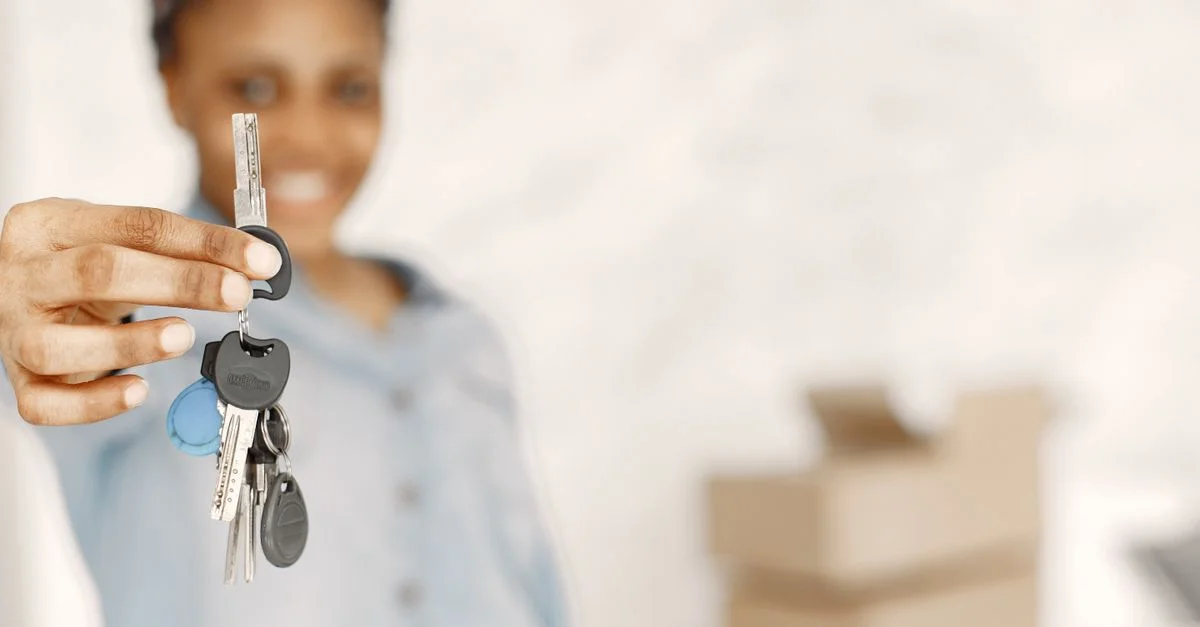 Gros plan sur une femme tenant des clés avec un arrière-plan flou, symbolisant un nouveau foyer ou un concept immobilier.