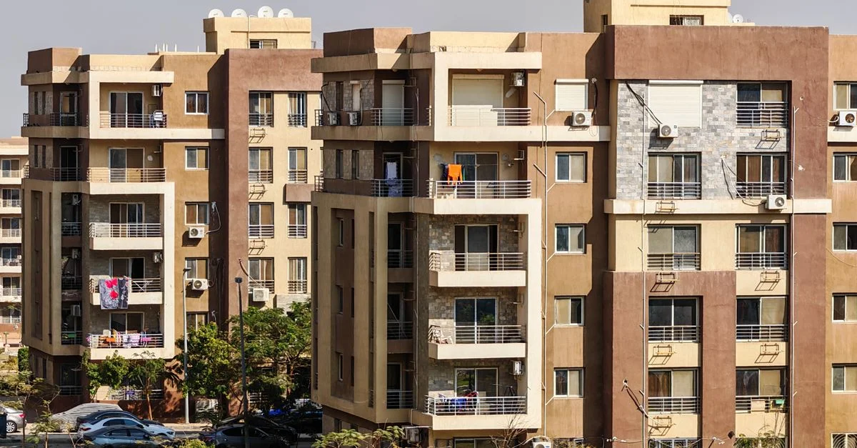 Bâtiments d'appartements contemporains à plusieurs étages dans un environnement urbain ensoleillé.