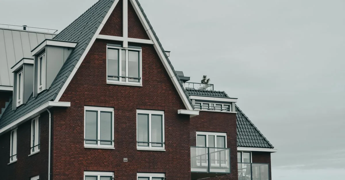 Une belle maison en brique à Amsterdam avec un toit à pignon et des fenêtres modernes, mettant en valeur l'architecture néerlandaise.