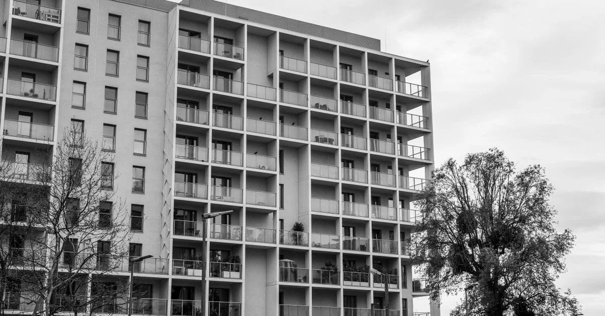 Photo en noir et blanc d'un immeuble moderne et d'arbres.